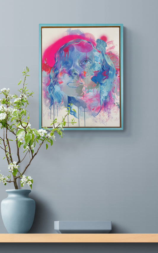 Blue framed artwork above table with vase and flowers