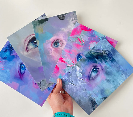 Image of hand holding 5 art postcards fanned out